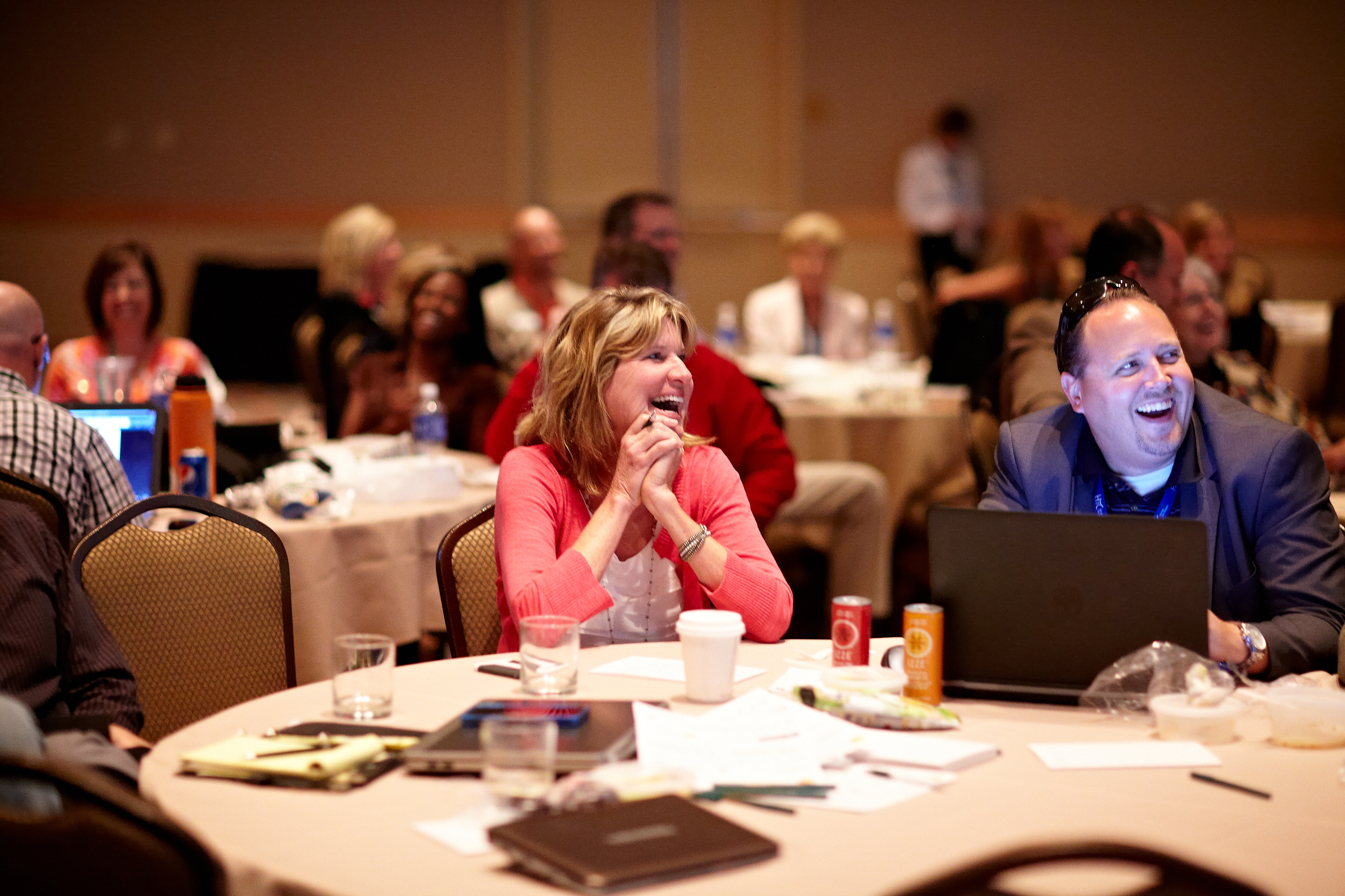 Image of two event attendees smiling during a Keynote speaker presentation