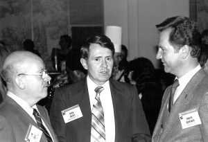 Jim Gale speaking with group of men at a conference