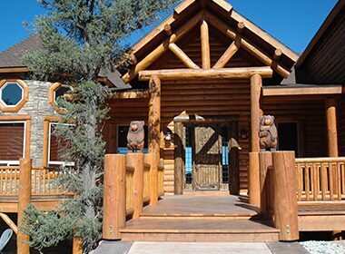 Log cabin entrance with carved bear statues.