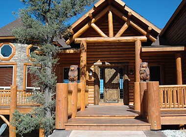 Log cabin entrance with carved bear statues.