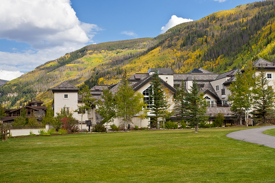 Mountain lodge surrounded by trees and hills.
