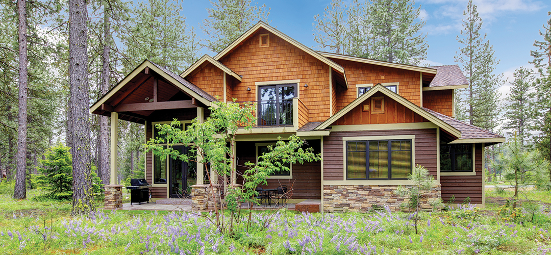 Rustic house surrounded by trees and flowers.